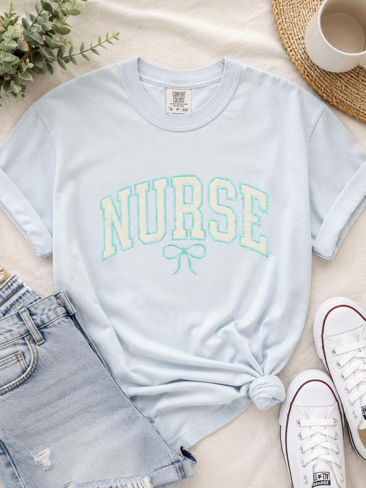 Nurse Varsity Bow glitter applique tee on Comfort Colors premium cotton, flat lay