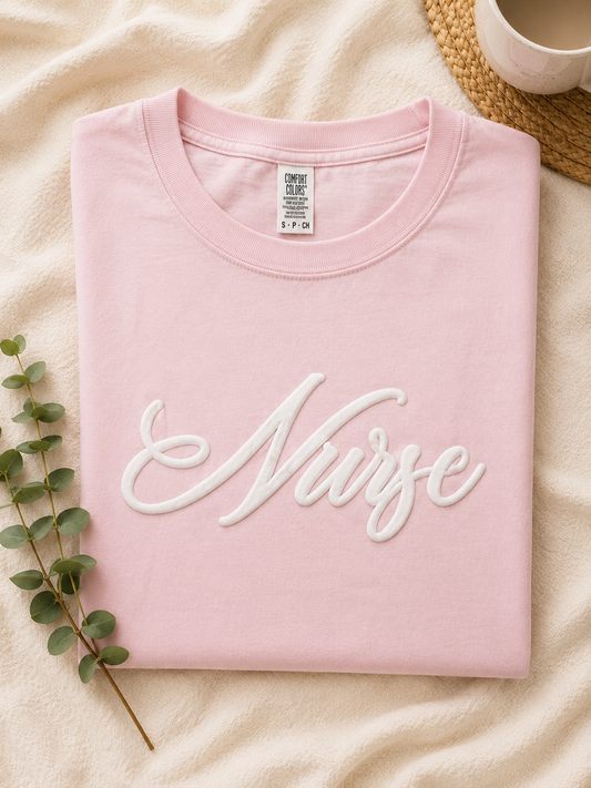 Nurse Script 3D Puff Tee in pink with raised puff lettering, flat lay