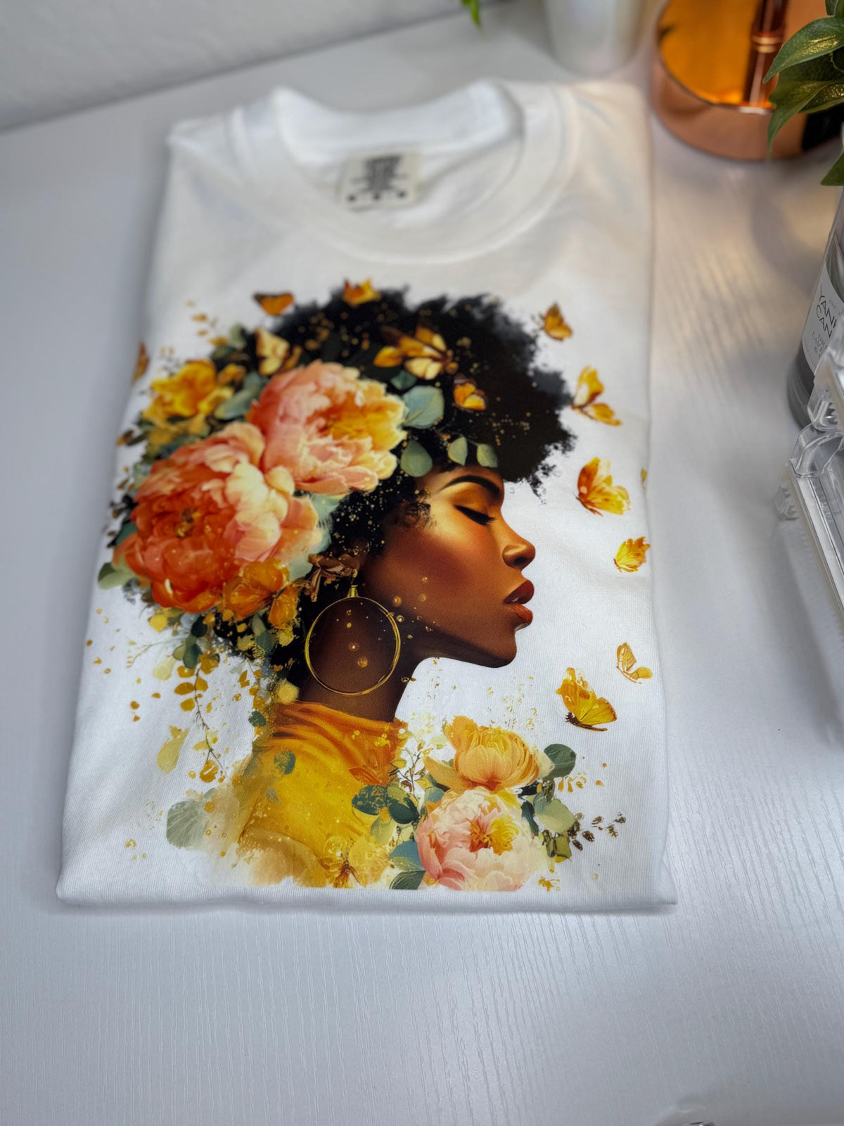 She Blooms graphic tee with floral and butterfly Black woman illustration